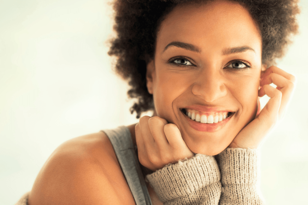 Smiling woman with a bright, confident smile, reflecting the kind of results cosmetic dentistry procedures can achieve.
