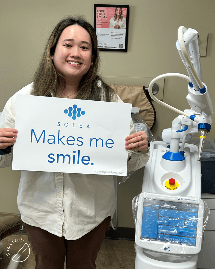 Happy patient holding “Solea makes me smile” sign after painless laser dentistry treatment at Somerset Dental in Calgary. Happy patient holding "Solea makes me smile" sign after painless laser dentistry treatment at Somerset Dental in Calgary.